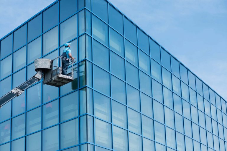 Window cleaner working on a glass facade in a crane
; Shutterstock ID 492242083; Purchase Order: -